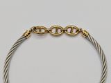 a close up of a gold and silver bracelet on a white surface