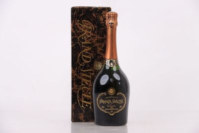 une bouteille de champagne devant un coffret