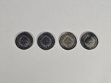 four different types of coins sitting on top of a white surface