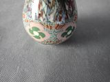 a vase with a flower inside of it on a table