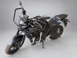 the black motorcycle is parked in a studio with a gray background