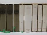 several books are lined up in a row on a white surface