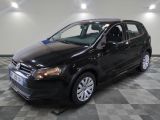the black volkswagen polo is parked on a checkered tile floor