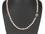 un collier de perles blanches sur un mannequin d'exposition