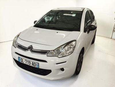une petite voiture blanche garée dans une pièce blanche