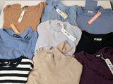 a lot of sweaters that are sitting on a table