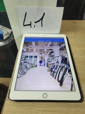 une tablette posée sur une table en bois, à côté d'une tasse de café