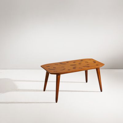 une table basse avec un plateau en bois posé sur un piètement blanc