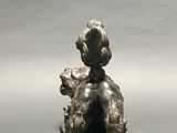 bronze figurine of a boy with a dog on his lap