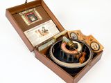 a wooden box with a compass and other items in it