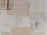 many old papers on a table with a cat sitting on it