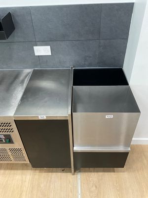 two trash bins in the corner of a kitchen