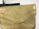 two purses and a handbag sitting on a white surface
