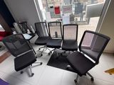 six office chairs in a room with a view of the city