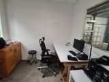 a room with two desks and a chair in it