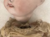 a close up of a doll on a white surface