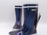 des bottes de pluie violettes à semelles blanches sur fond blanc