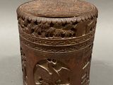an old wooden box with carvings on it sitting on top of a table