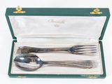 two spoons and a fork in a green box