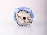 a close up of a blue and white ceramic bead on a white surface