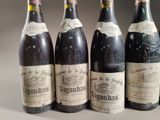 four bottles of wine are lined up on a table