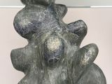 a stone sculpture of a man and a woman sitting on a rock