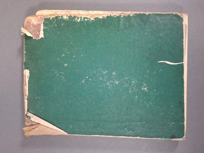 un livre vert aux pages déchirées posé sur une table