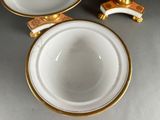 a white bowl and a gold plate on a table