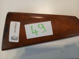an old wooden rifle with a number on the side and a sticker attached to it
