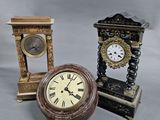 three different types of clocks sitting next to each other on a gray surface