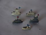 five small toy ships on a white surface
