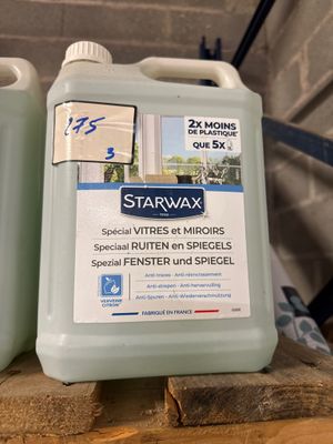 Deux bouteilles de Starwax sont posées sur une palette en bois