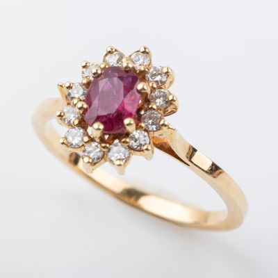 a close up of a pink sapphire and diamond ring on a white background