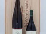 two bottles of wine in front of a wooden box on a table