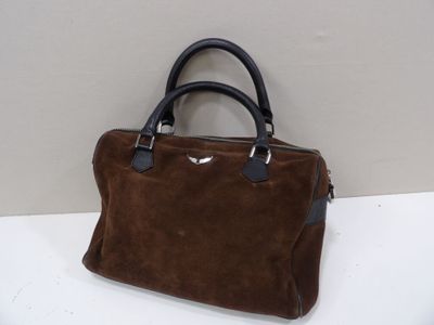 brown sued handbag with black leather handles on a white surface