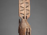 a wooden sculpture of a man ' s head on a stand
