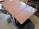 a table with a chair and a microwave in the background