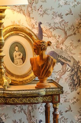 une table sur laquelle se trouvent une lampe et une image représentant un oiseau