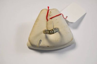 un anneau fixé au sommet d'un petit sac muni d'un cordon rouge