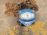 a blue water meter sitting on the ground next to chains