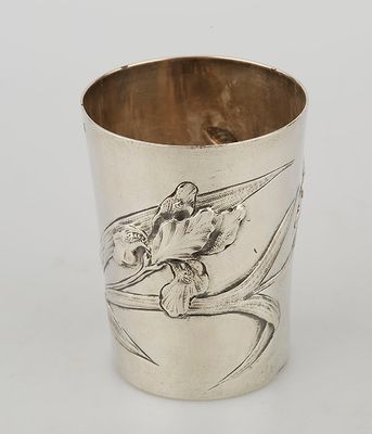 a silver cup with a bird on it and a flower on the side