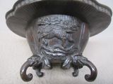 a metal vase with a dragon on it on a table
