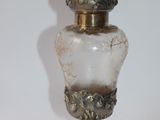 a glass bottle with a bird on top of it