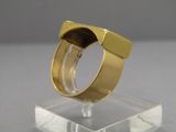 une image représentant une bague en or posée sur un socle transparent