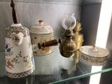 une étagère en verre sur laquelle sont disposées de nombreuses théières de styles variés