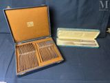 un coffret contenant de l'argenterie, posé sur une nappe bleue