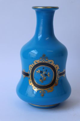 un vase bleu orné d'une décoration dorée