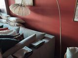 une image d'un salon avec un canapé et une lampe