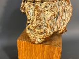 a close up of a sculpture of a lion ' s head on a wooden block