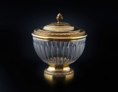 une image représentant un bol recouvert d'or et de cristal posé sur une surface noire